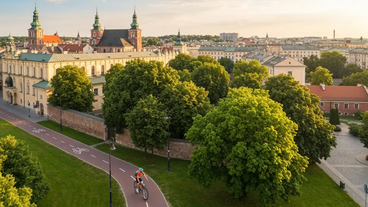 Kraków rowerem - widok na Stare Miasto z perspektywy cyklisty jadącego po ścieżce rowerowej wśród zieleni miasta